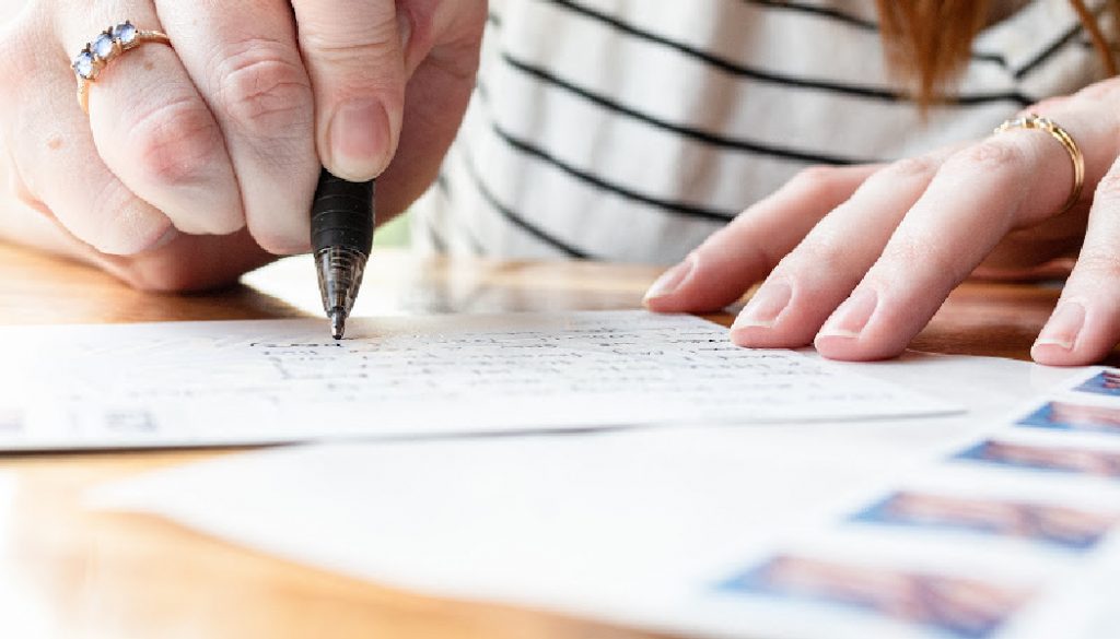 A woman writes a letter to a friend.